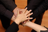 Foto con manos unidas, unas encima de otras.