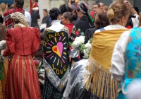 Ilustración de varias personas andando por la calle, con mantones de manila a sus espaldas.