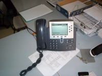 En la foto se ve un primer plano de un teléfono centralita de color gris.