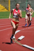 Se ven a dos corredoras de atletismo con traje rojo, una delante de la otra.     
