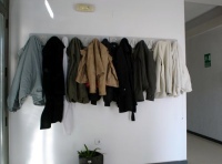 Se ve el perchero de la oficina repleto de abrigos de los trabajadores  y trabajadoras.