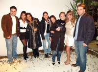 En la imagen se observa a un grupo de jóvenes, chicos y chicas, muy arreglados y sonrientes, todos de pie en semicírculo frente a la cámara.