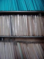 Estantería llena de documentos clasificados en diferentes fundas y carpetas.